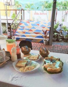 a white table with plates of food on it at Villa Seresa Room A in Pagsanjan
