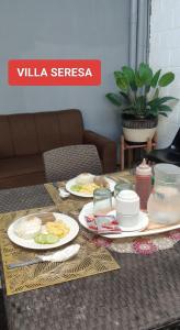 a table with plates of food on top of it at Villa Seresa Room A in Pagsanjan