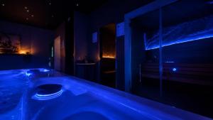 a bathroom with a tub with blue lighting at ES Apartments in Nago-Torbole +50 photos