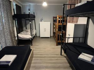 a dorm room with bunk beds and a room with at Palma Hostel in Batumi