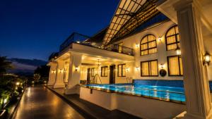 a house with a swimming pool at night at Rivora Villa in Nashik +2 photos