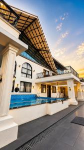 an exterior view of a building with a swimming pool at Rivora Villa in Nashik