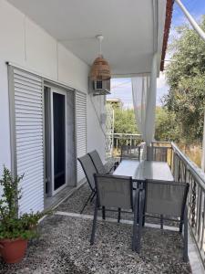 a patio with a table and chairs on a balcony at Villa Ipomoni in Skala Sotiros