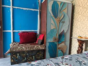 a room with a bench with a blue wall at Theprefabnest in Rishīkesh