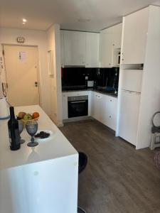 a kitchen with white cabinets and a bowl of fruit on a counter at Rochavaumar in Portimão