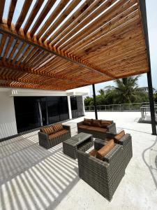 a patio with two couches and a wooden pergola at Serian Breeze 6 Bedroom Villa Diani in Ukunda