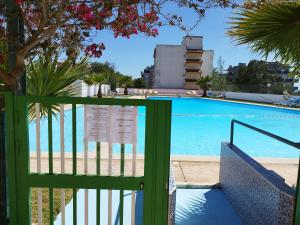 a swimming pool with a green fence next to it at Rochavaumar in Portimão
