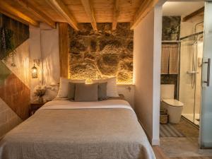 a bedroom with a large bed and a bathroom at Holibai Mirada do Roxo 3 suites y vistas al mar in Oia