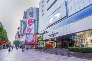 a city street with people walking in front of buildings at Radisson Collection Hyland Shanghai in Shanghai
