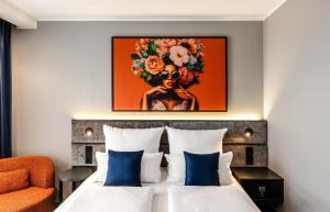 a hotel room with a bed with blue pillows at Aiden by Best Western Velbert in Velbert