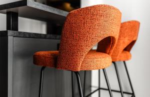 two orange chairs in front of a fireplace at Aiden by Best Western Velbert in Velbert
