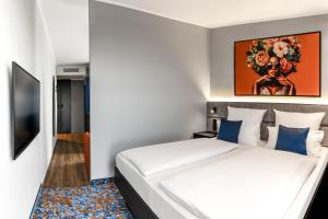 a hotel room with a bed and a television at Aiden by Best Western Velbert in Velbert