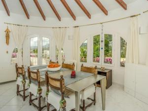 a dining room with a table and chairs and windows at Gorgeous villa with private pool and near golf course and beach in Benissa