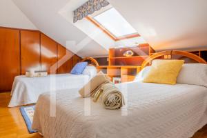 a bedroom with two beds and a window at El Jardin de Pruvia in Llanera