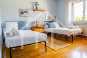 a bedroom with two beds and a stair case at El Jardin de Pruvia in Llanera