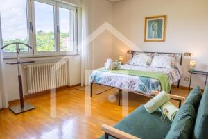 a small bedroom with a bed and a couch at El Jardin de Pruvia in Llanera