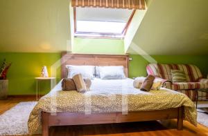 a bedroom with a bed and a window and a couch at El Jardin de Pruvia in Llanera