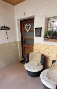 a room with two chairs in front of a door at Maison Cavalese - Polar Express in Cavalese