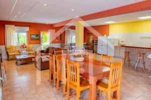 a kitchen and living room with a wooden table and chairs at El Jardin de Pruvia in Llanera +52 photos