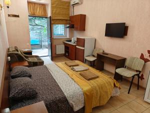 a bedroom with a bed and a desk and a kitchen at Shellman Apart Hotel in Odesa