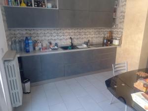 a kitchen with a sink and a counter with a table at Casa Floris in Imola