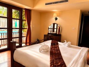 a bedroom with a bed with two towels on it at Shewe Wana Suite Resort in Chiang Mai +77 photos