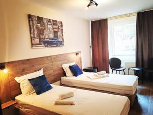 two beds in a hotel room with a car on the wall at Hotel Sorbona in Varna City