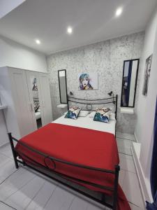 a bedroom with a large bed with a red blanket at Albicocche house Catania in Catania