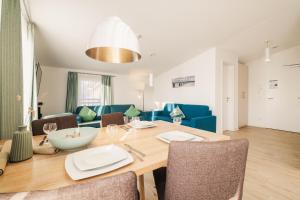 a dining room and living room with a table and chairs at Am Park 26 in Prerow