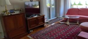 a living room with a pink couch and a tv at Bungalow Au in Illertissen +13 photos