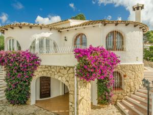 a house with purple flowers in front of it at Gorgeous villa with private pool and near golf course and beach in Benissa