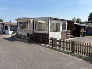 a small house with a fence next to it at Zeester 91 in Scherpenisse +8 photos
