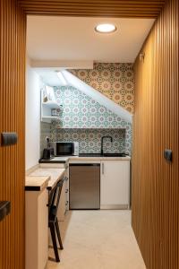 a kitchen with a sink and a stove top oven at Hostal ZENTRAL in Alora