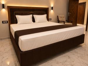 a bedroom with a large bed with a wooden headboard at Hotel Bhagirath Palace in Ahraurā Road
