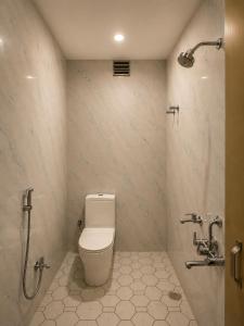 a bathroom with a toilet and a shower at Hotel Bhagirath Palace in Ahraurā Road