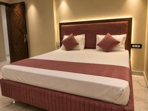 a bedroom with a large bed with pillows at Hotel Bhagirath Palace in Ahraurā Road +4 photos