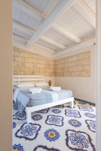 a bedroom with a bed and a blue and white rug at Tenuta Monsalvato in Otranto +218 photos