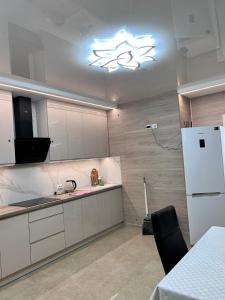 a kitchen with white cabinets and a white refrigerator at Дім Гаваї in Chechelivka