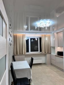 a room with a table and chairs and a window at Дім Гаваї in Chechelivka