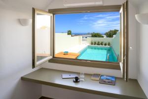 a room with a window with a view of a swimming pool at Kaminia Holiday Homes in Éxo Goniá +90 photos