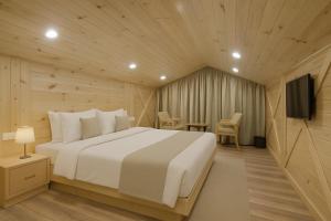 a bedroom with a bed and a television in it at The Manali Suites & Villas, Manali - Luxury Stay Away From City Hustle in Manāli