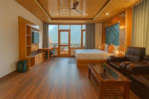 a hotel room with a bed and a couch at The Manali Suites & Villas, Manali - Luxury Stay Away From City Hustle in Manāli