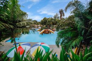 a resort swimming pool with umbrellas and people in the water at Hotel La Vista by Grotto Vista in Mangangpico +18 photos