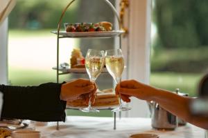 two people holding champagne glasses in front of a cake at Farington Lodge Hotel in Preston
