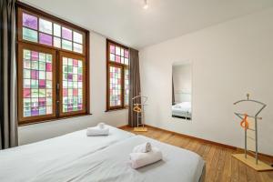 a bedroom with a large bed with towels on it at Parkhuisje by BLOSS in Bruges