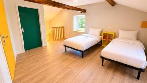 a room with two beds and a green door at Maison 8 personnes avec terrasse in Verdun