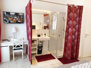 a bathroom with a shower and a sink and a desk at Pension am Wienfluss in Vienna +43 photos