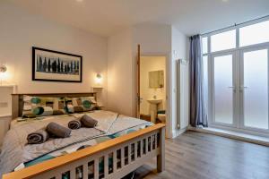 a bedroom with a large bed and a large window at Dizzy Lows Modern 1 Bedroom Swanage Apartment with Sea View in Swanage