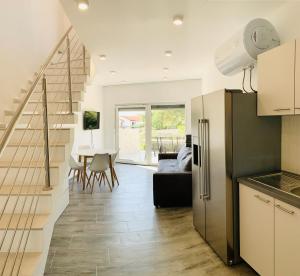a kitchen with a refrigerator and a dining room at Villa Legacy with privat heating pool in Novalja