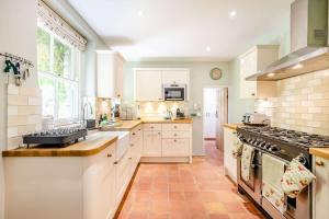 a kitchen with white cabinets and a stove top oven at Passiflora Cottage Close to Swanage Beach and Town Sleeps 7 in Swanage